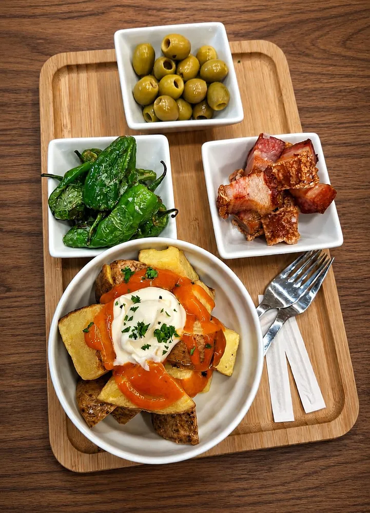 Bandeja de pimientos de Padrón, torreznos, olivas y patatas bravas